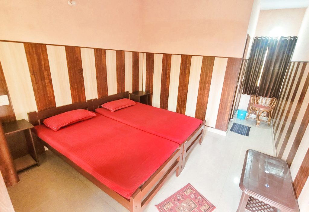 Shared comfort and serenity: Experience the tranquility of the twin shared rooms at Sage House Yoga's retreat center from the inside. The room is thoughtfully arranged with two cozy beds, personal storage spaces, and a soothing atmosphere, inviting guests to unwind and relax in a peaceful setting during their stay.