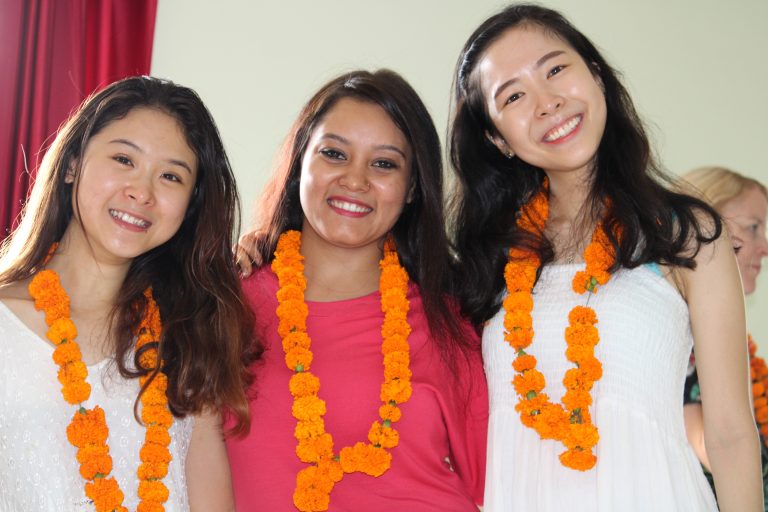 Group of girls smiling and posing for a photo after the closing ceremony of a yoga course at Sage House Yoga