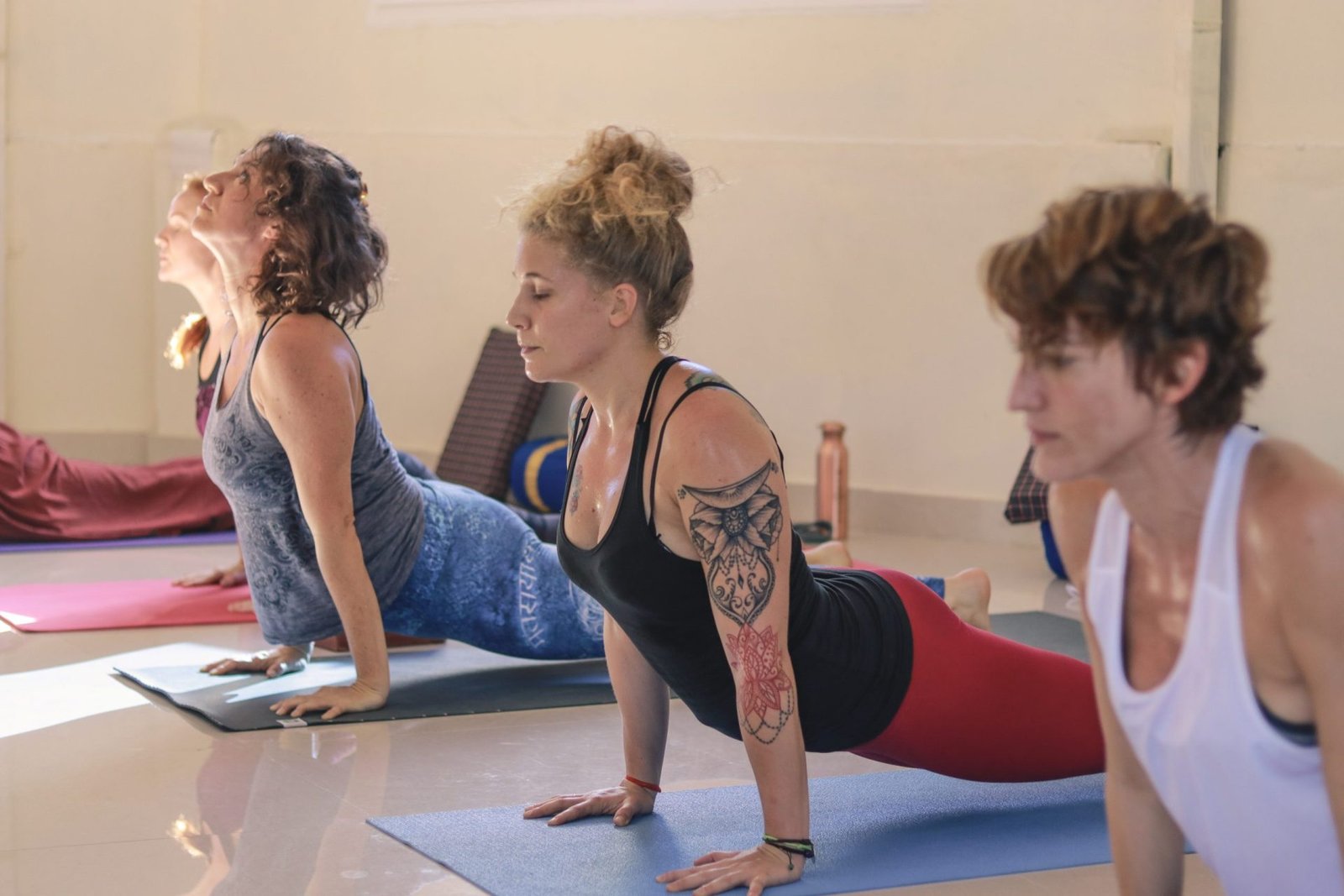 Strength and balance in action at Sage House Yoga: Girls confidently hold the Chair Pose, embodying stability and focus during the invigorating yoga class.