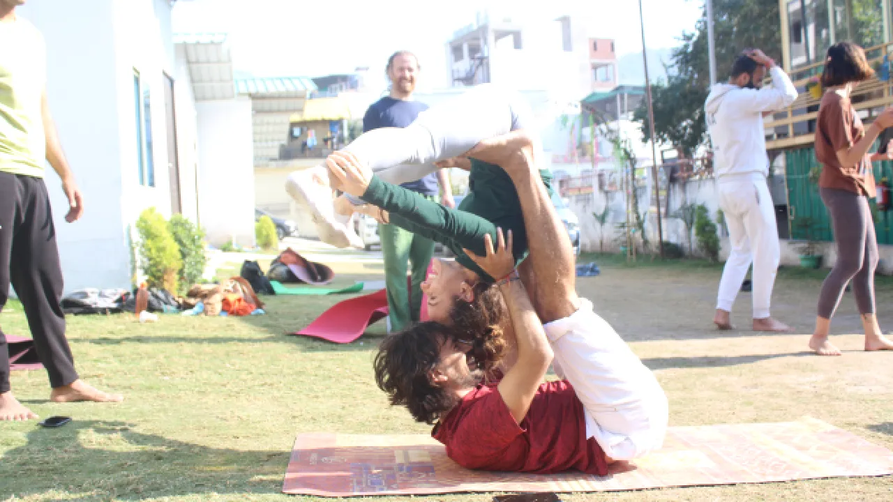 Yoga students practicing partner acro yoga at Sage House Yoga Rishikesh